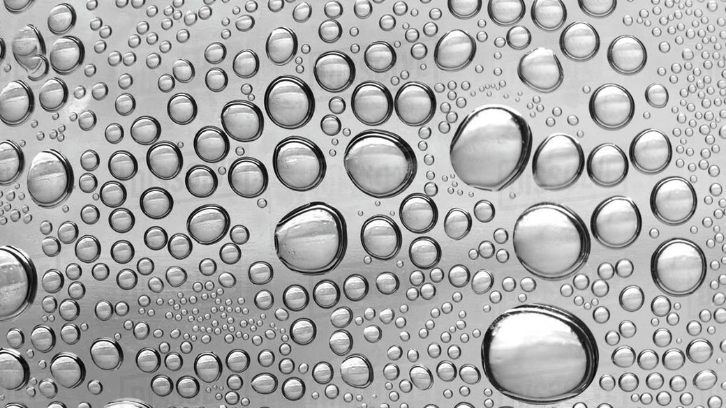 Kapky čisté vody na kovovém povrchu